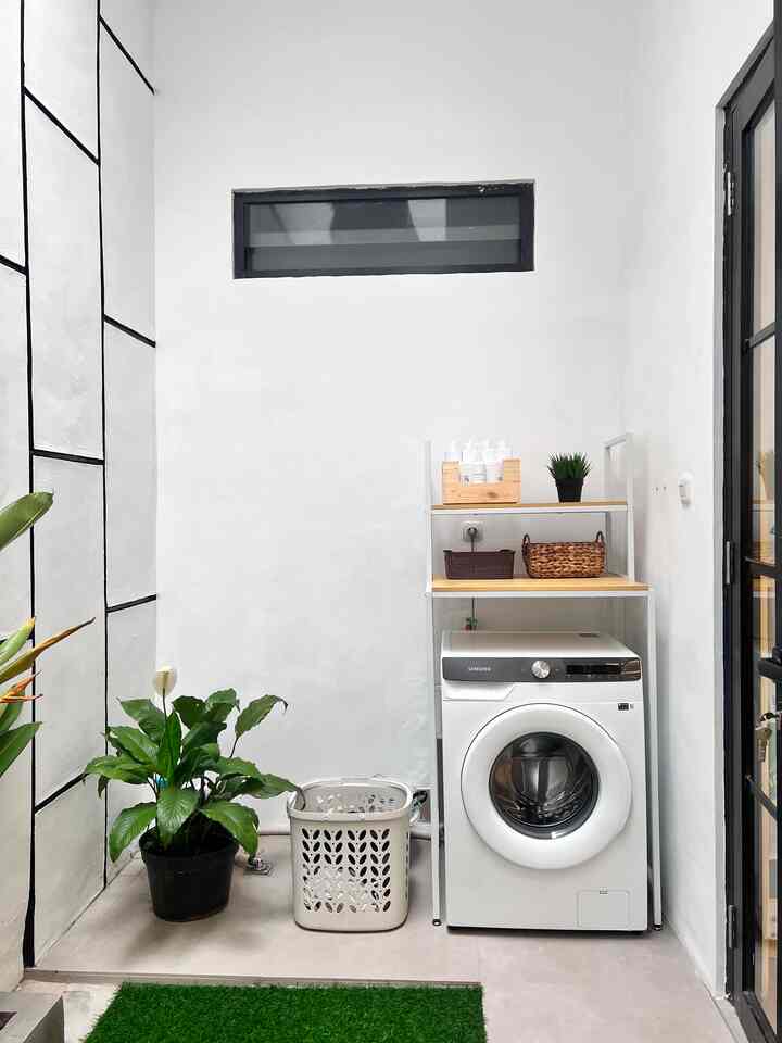 White and wood tone long and narrow laundry room featuring shelving units and plants with a natural aesthetic