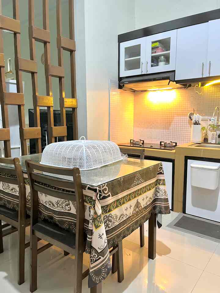 Natural style small kitchen featuring brown wood dining table set with white walls and tiled backsplash, providing a practical atmosphere