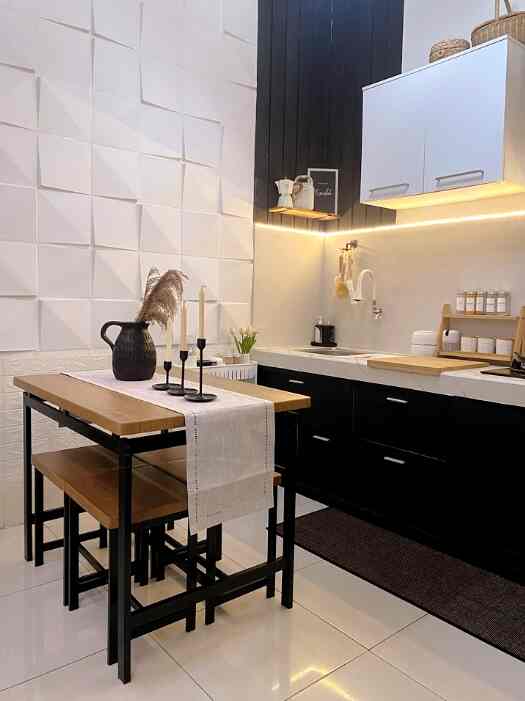 Minimal dining room and kitchen featuring white walls, black lower cabinets, wooden dining table with table runner