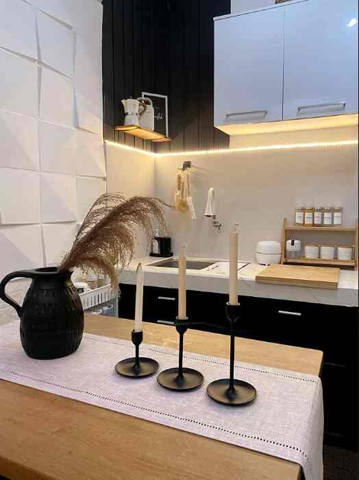 Black and natural tone kitchen with dining table, featuring a clean and modern atmosphere