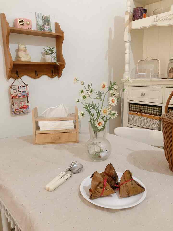 Beige table runner and natural wood furniture with vase of flowers in a cozy white-toned dining space