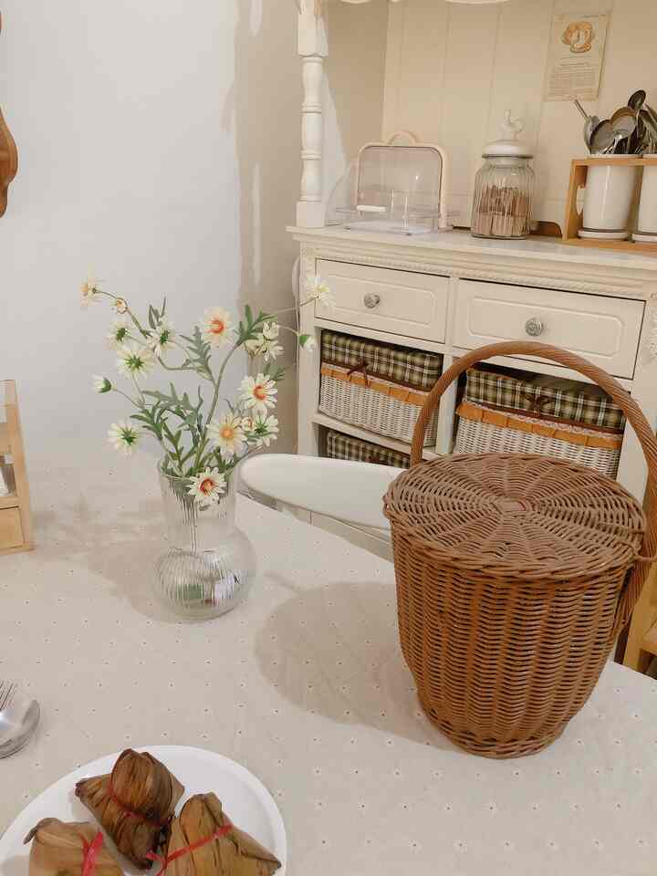 Beige-toned dining room featuring a rattan basket and artificial flowers, creating a soft and natural ambiance