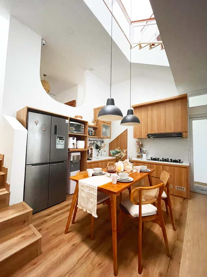 Wood tone dining room featuring wooden table and pendant lights, creating a cozy and modern atmosphere