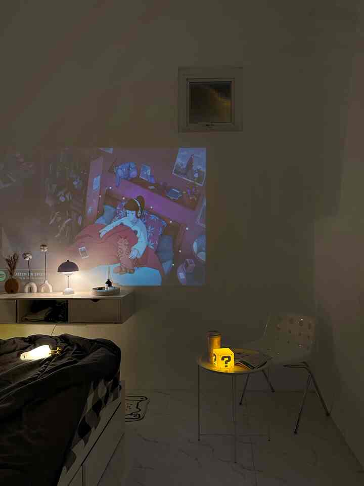 White and black toned small bedroom featuring animation projection on wall and simple furniture arrangement