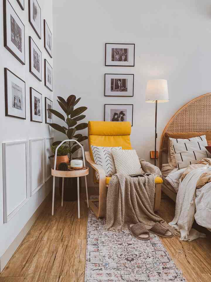 White and natural toned bedroom featuring a Nordic yellow armchair and patterned rug with a cozy atmosphere