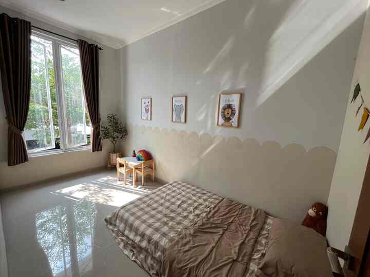 A calm natural color kids' room featuring a small wooden play desk and a bed with warm beige and brown tones