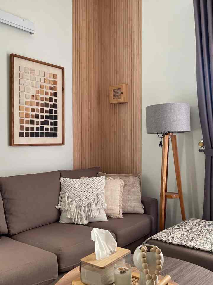 Soft brown and wood-tone living room featuring a sectional sofa and floor lamp with natural, simple ambiance