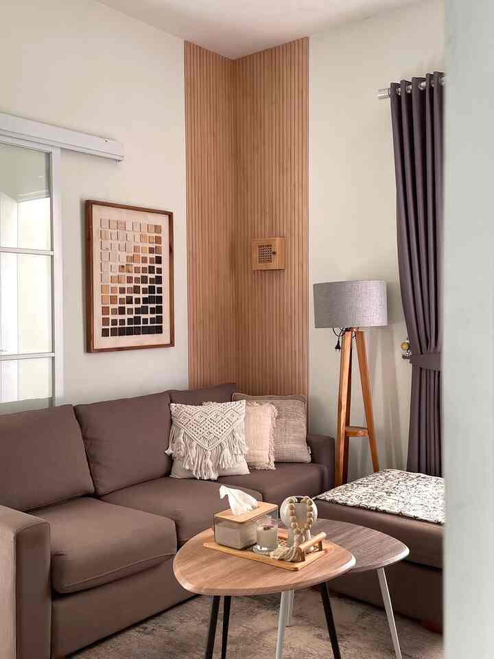 Warm and cozy Japandi living room featuring natural wood tones, brown sectional sofa, wooden tables, and a floor lamp