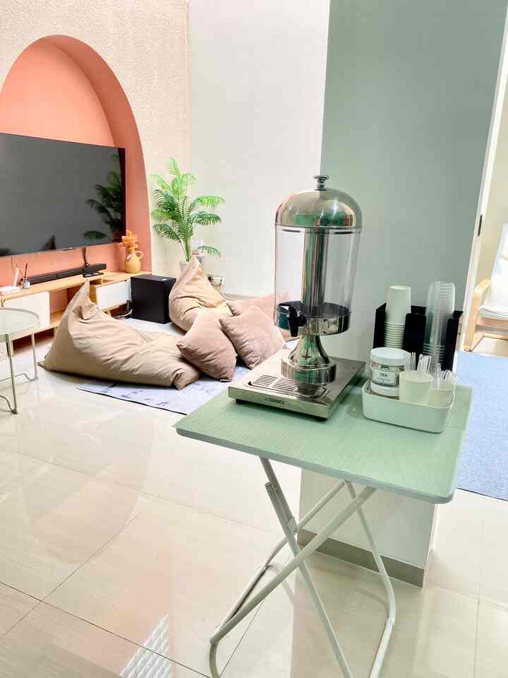 Beige and white toned living room with arched wall TV and bean bags arranged in cozy home cafe setting
