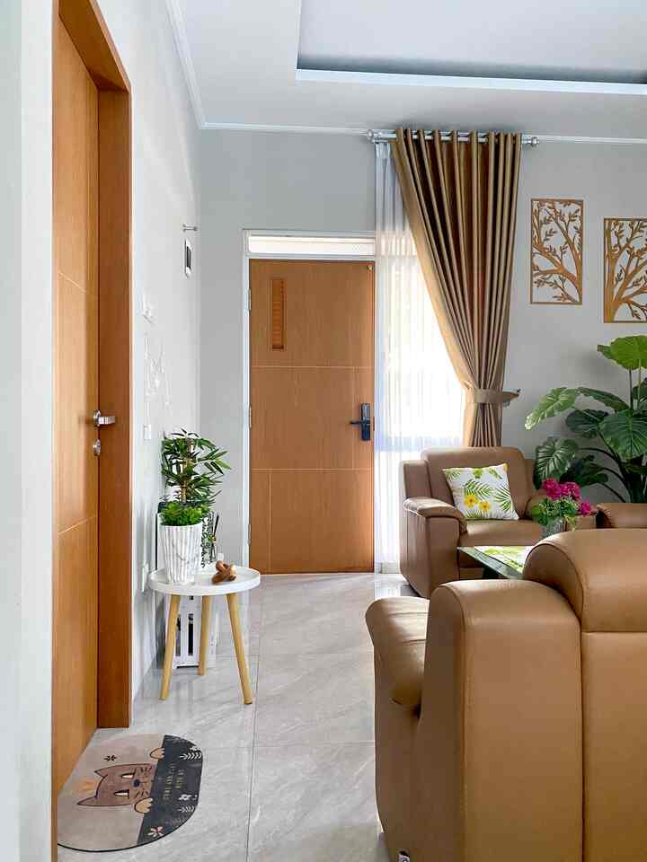 Brown and white toned living room featuring sofas, coffee table, and plants creating a warm natural atmosphere