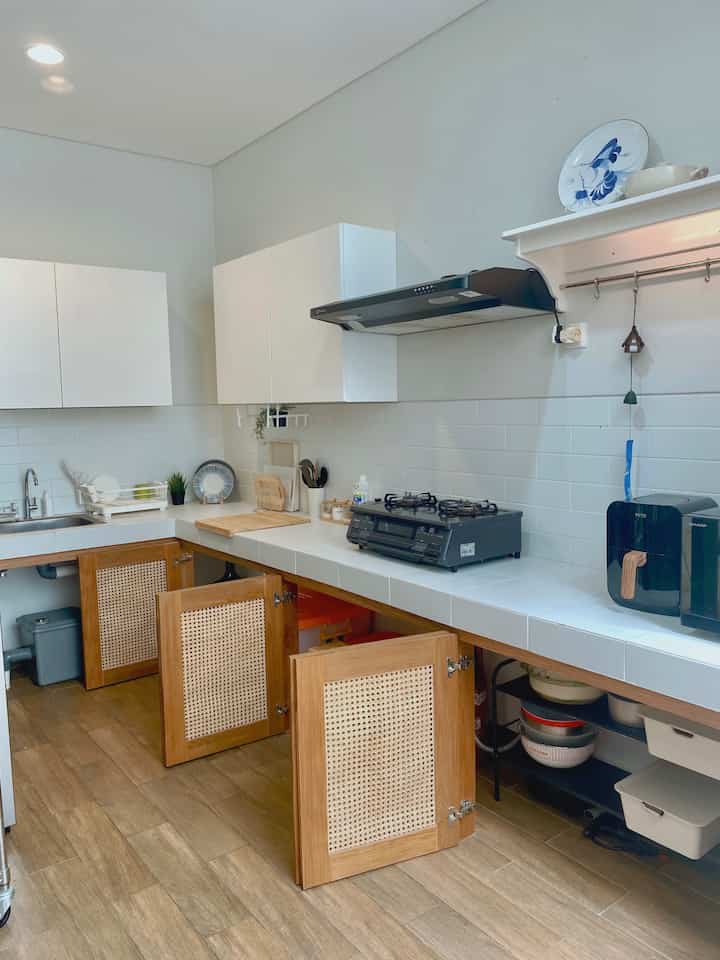 Natural color and white kitchen featuring wooden floors and kitchen utensils with a neat, minimal atmosphere