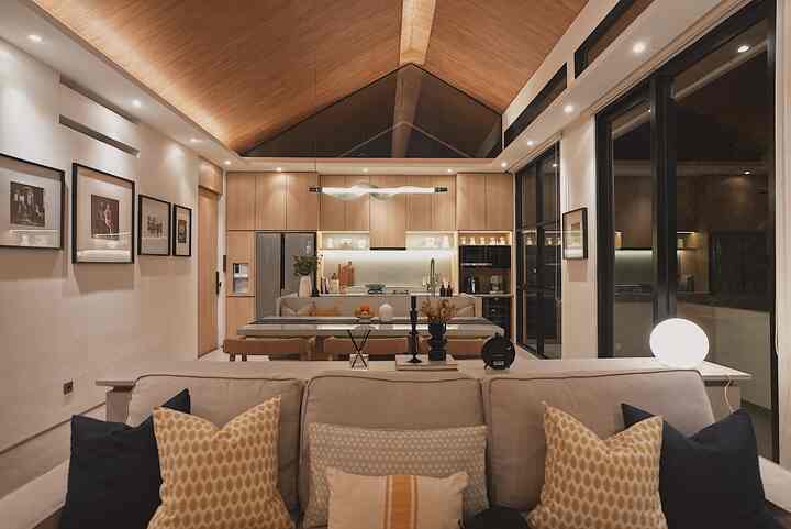 A natural modern living room and kitchen space with wood tones and beige hues, creating a warm and contemporary atmosphere