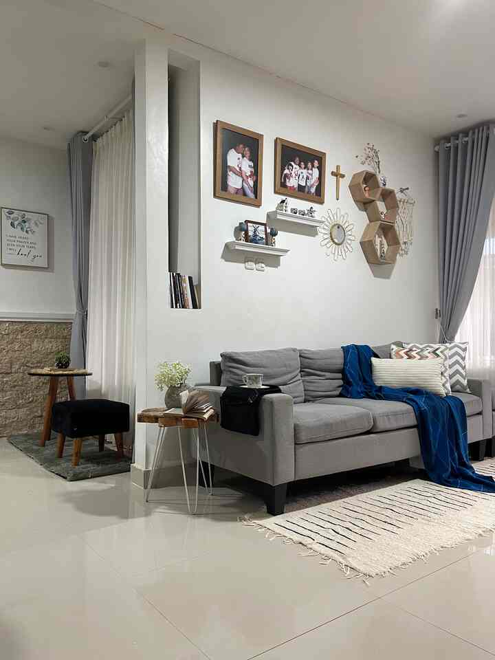 White walls and gray sofa in a cozy natural Nordic style living room for a 4-person household