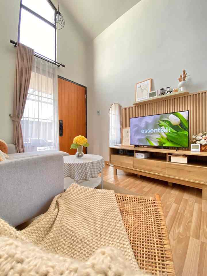 Bright white and wood tones blend in a natural living room featuring a cozy sofa and wooden TV stand
