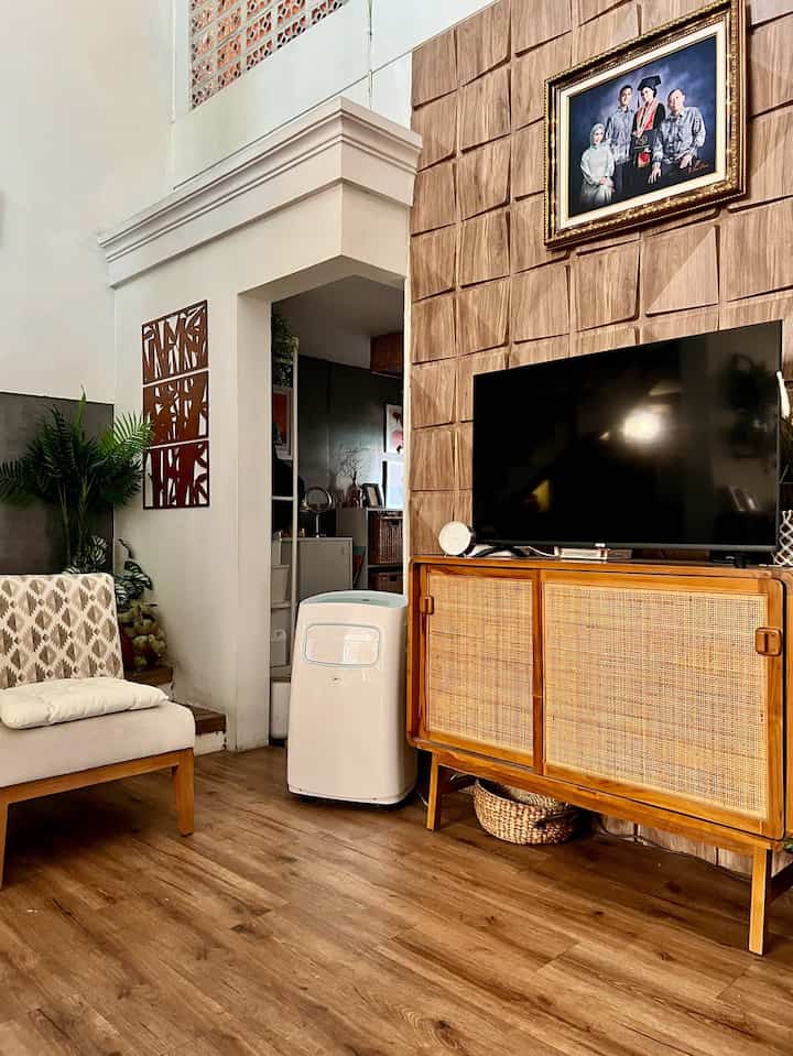 Wood tone and beige living room featuring cabinet and armchair with natural, cozy atmosphere