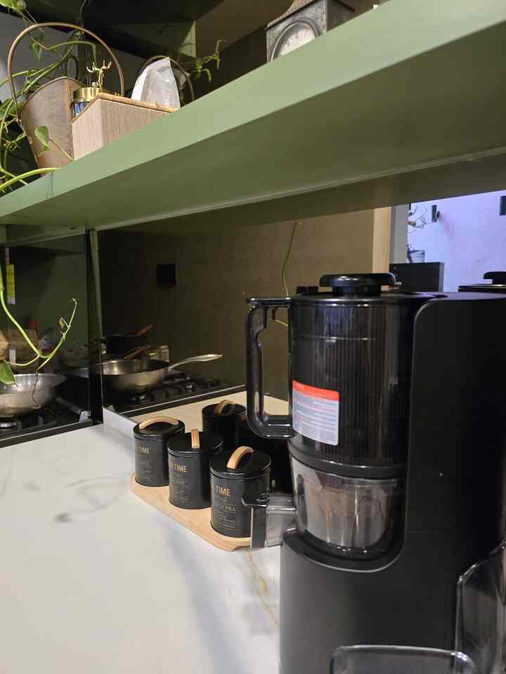 Natural color tone kitchen featuring a black coffee machine and three tea canisters with wooden handles neatly arranged