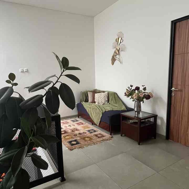 Navy sofa bed and green accents in a small living room featuring natural tones and golden wall art for a cozy interior