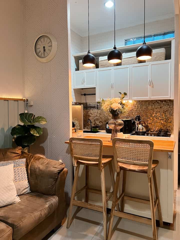 White and brown toned kitchen featuring a kitchen island and bar stools with a cozy natural atmosphere