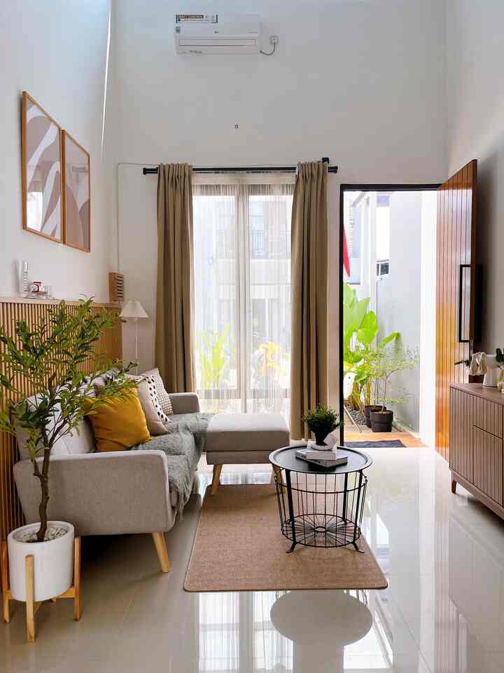 Natural modern living room with beige curtains and wood-toned cabinet, featuring a mid-tone sofa with yellow accent cushions