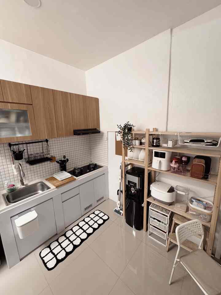 Simple small kitchen space featuring brown wooden upper cabinets and white lower cabinets with organized shelving
