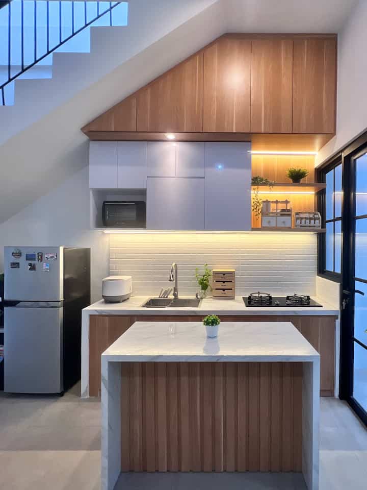 Salam dari dapur segaris dirumahku. Dari awal membuat dapur ini suami ingin menggunakan meja cor karena akan lebih awet dan kokoh. Agar lebih estetik seperti pakai top table. Aku menggunakan teknik adu manis pada saat pemasangan granite tile sebagai top tablenya. Dengan panjang meja cor 2,4 m aku rasa cukup fungsional karena aku tidak memasak dalam jumlah yang besar. Agar senada dengan tema rumah aku pilih finishing HPL motif kayu kombinasi warna putih. Dengan dilengkapi kitchen island aksen kisi kisi menambah estetika dan fungsional sebagai tambahan meja preparation sekaligus untuk meja makan nantinya. Kabinet full plafon sangat berfungsi untuk penyimpanan barang barang dapur. Aku memilih perabotan dapur seperti wadah bumbu, bawang dengan motif kayu agar senada dengan kitchen set. 

#mydreamkitchen #idedekordapur #dapurestetik #dapurimpian #desaindapur #kitchendesign #dapurjapandi #japandi #depok #dapurmungil #dapursegaris