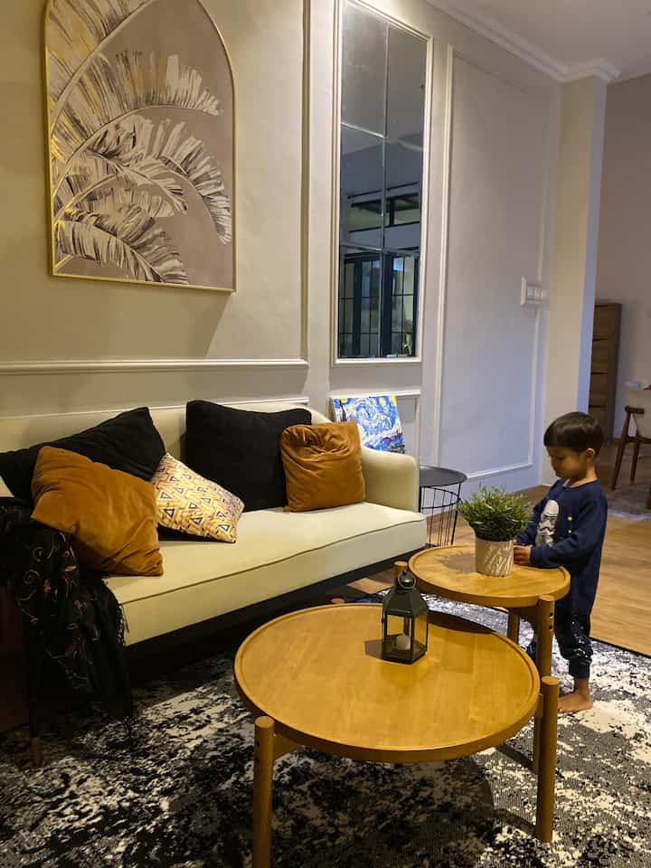 Natural-toned living room featuring cream sofa and wooden coffee tables with a warm atmosphere