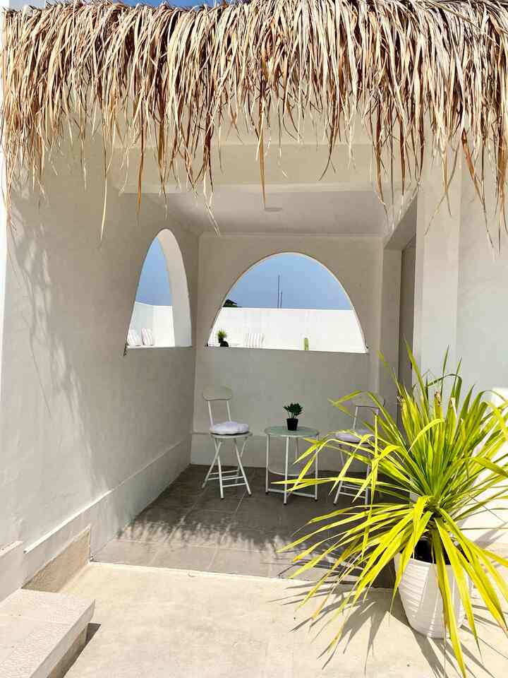 Natural and white toned veranda with outdoor chairs and table, creating a cozy atmosphere