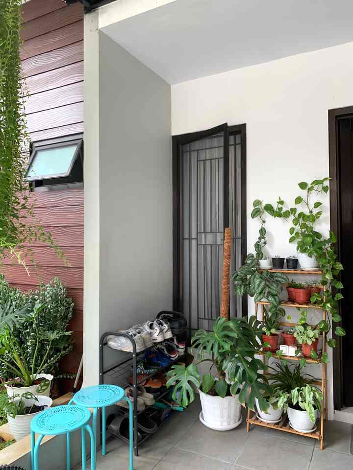 Natural-toned entrance space featuring shoe rack and plants with a clean and cozy atmosphere