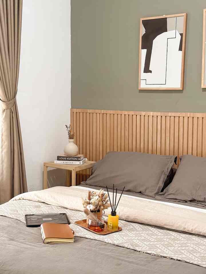 Beige and wood-tone bedroom featuring a large bed with cozy decor elements and soft curtains for a calming atmosphere