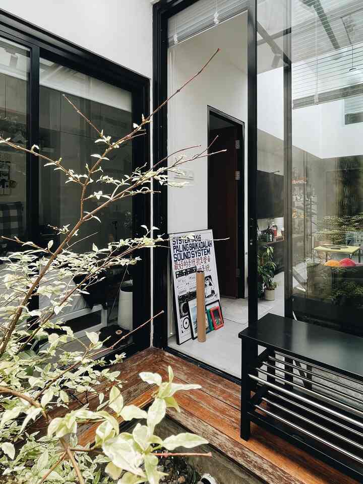Black and wood tone entrance space featuring plants, pet toys, and TJUSIG bench with natural atmosphere