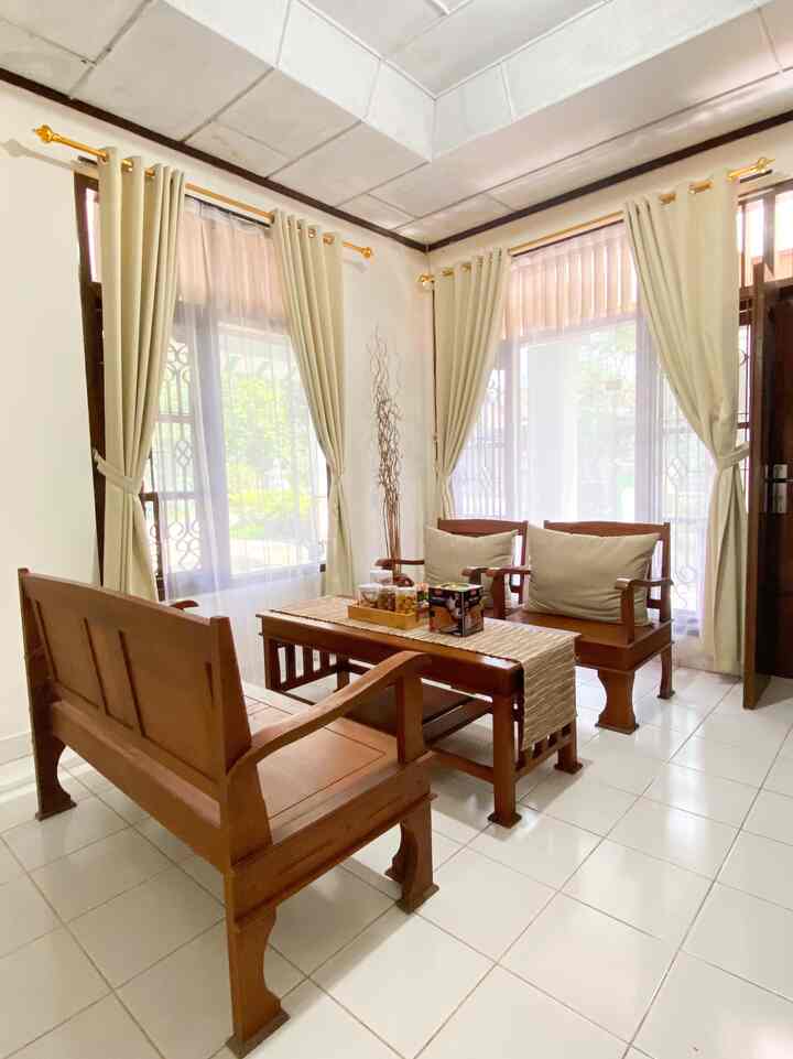 Beige curtains and brown wooden furniture in a cozy living room space