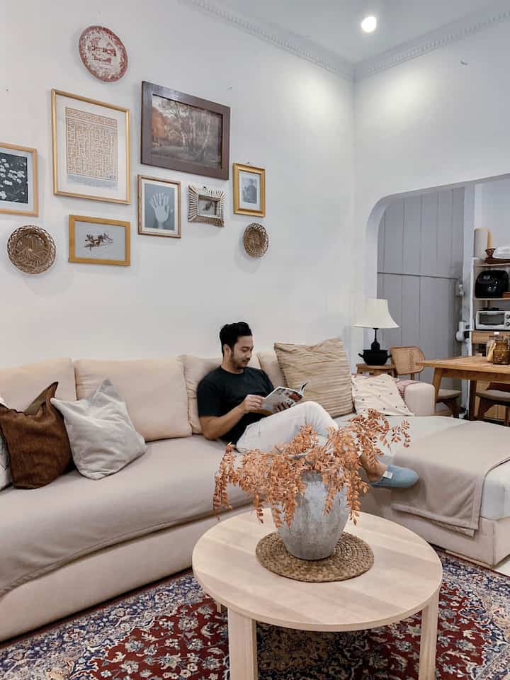 Beige and white toned living room featuring a sectional sofa and round coffee table with a cozy atmosphere