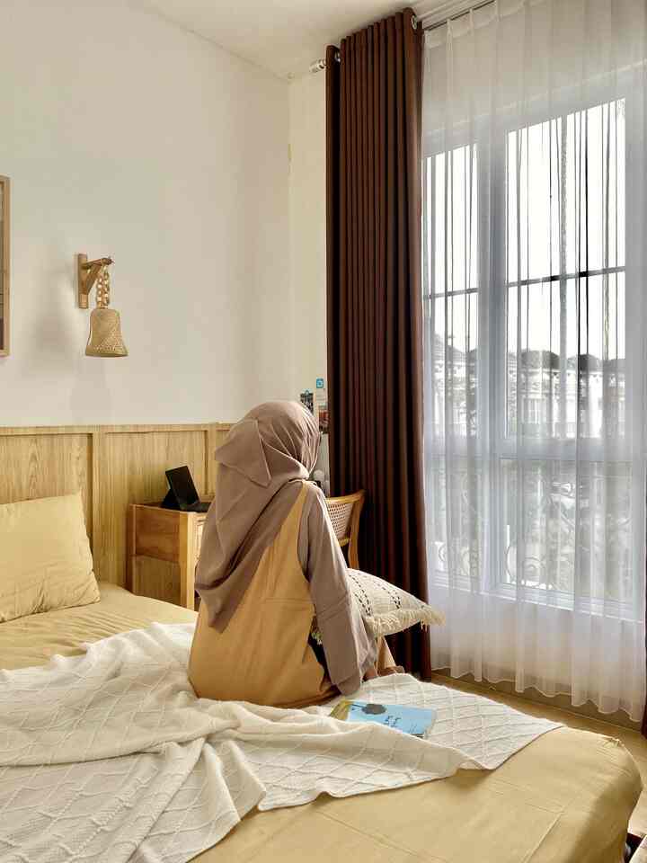 Beige and wood tone bedroom featuring bed and curtains with a natural and cozy atmosphere