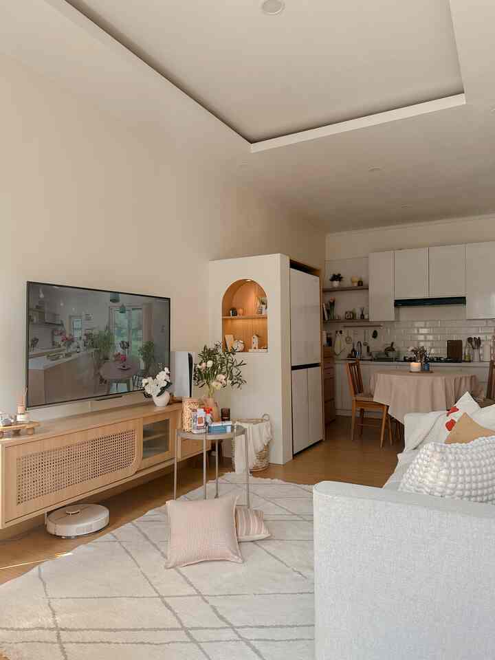 White and beige toned living room and dining area featuring natural modern elements with cozy atmosphere