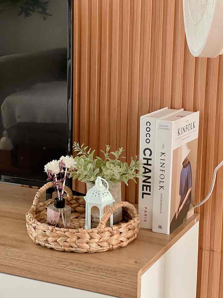 Natural wood tone furniture with tray holding decorative items in a Nordic-style living room corner