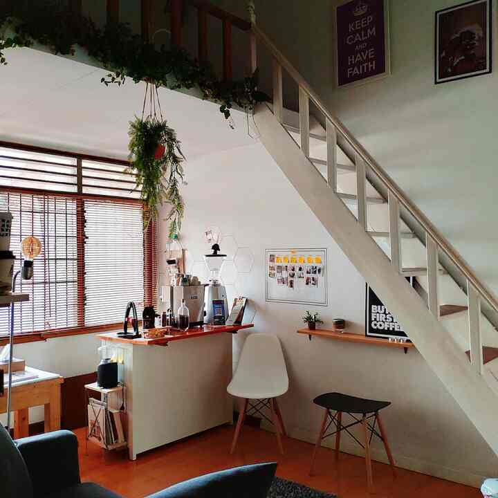 White and wood tone compact home cafe space featuring coffee bar and chairs with a cozy atmosphere