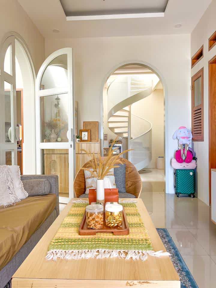 Beige-toned living room featuring wood tone dining table and sofa, creating a cozy and natural atmosphere