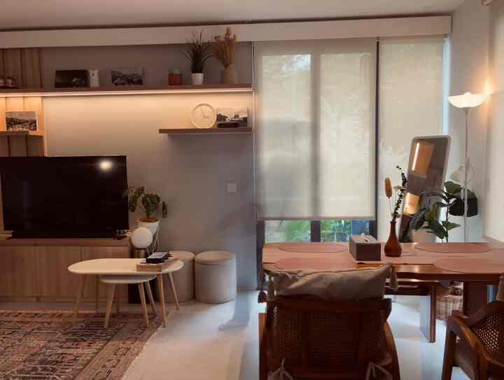 Modern living room with natural wood tones and black accents, featuring curtains and a floor lamp in a cozy atmosphere