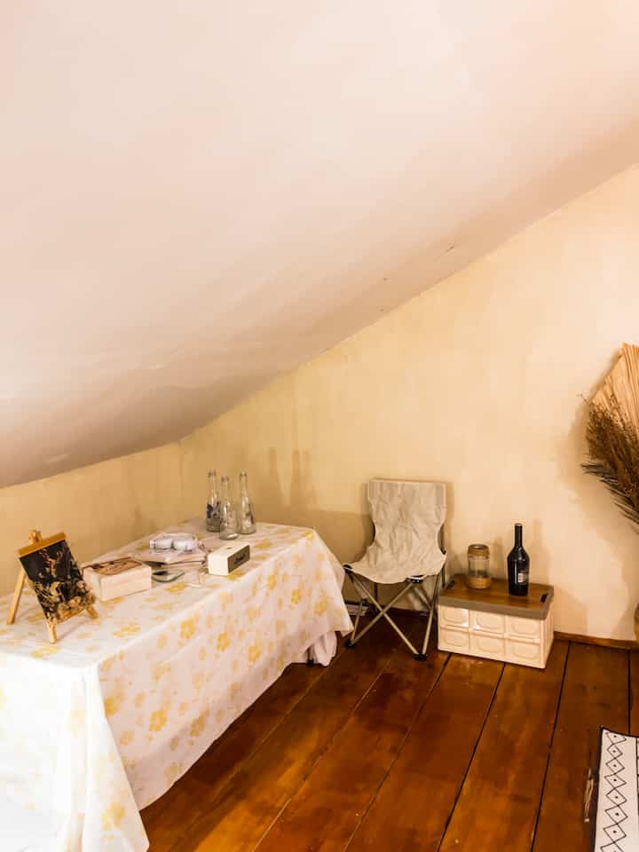 Cozy rooftop room with warm natural tones featuring a camping chair and floral tablecloth for relaxing