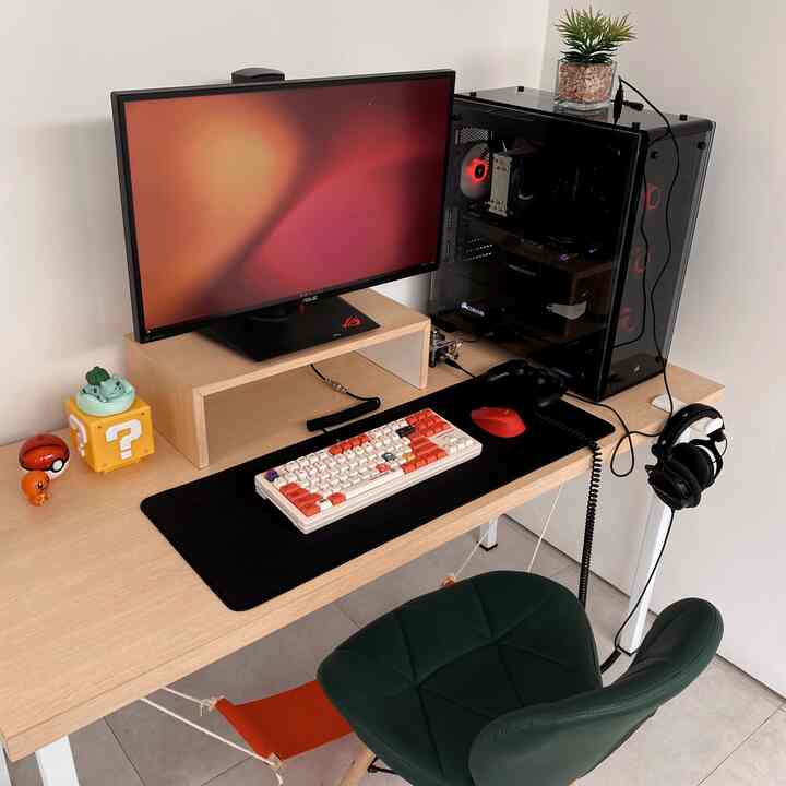 Warm beige-toned game room featuring a Mario-themed keyboard and black gaming desk setup in a cozy workspace
