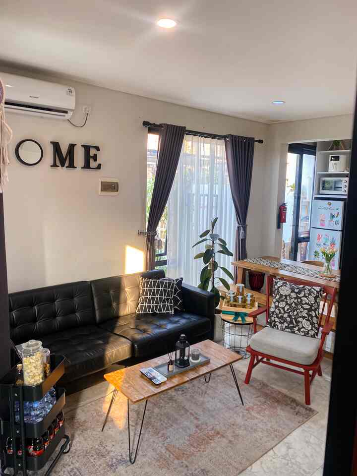 White background living room featuring black leather sofa, wooden coffee table, and armchair in a natural modern style