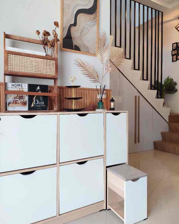 Natural wood tone and white entrance space featuring storage cabinets and a small stool, creating a clean and organized interior