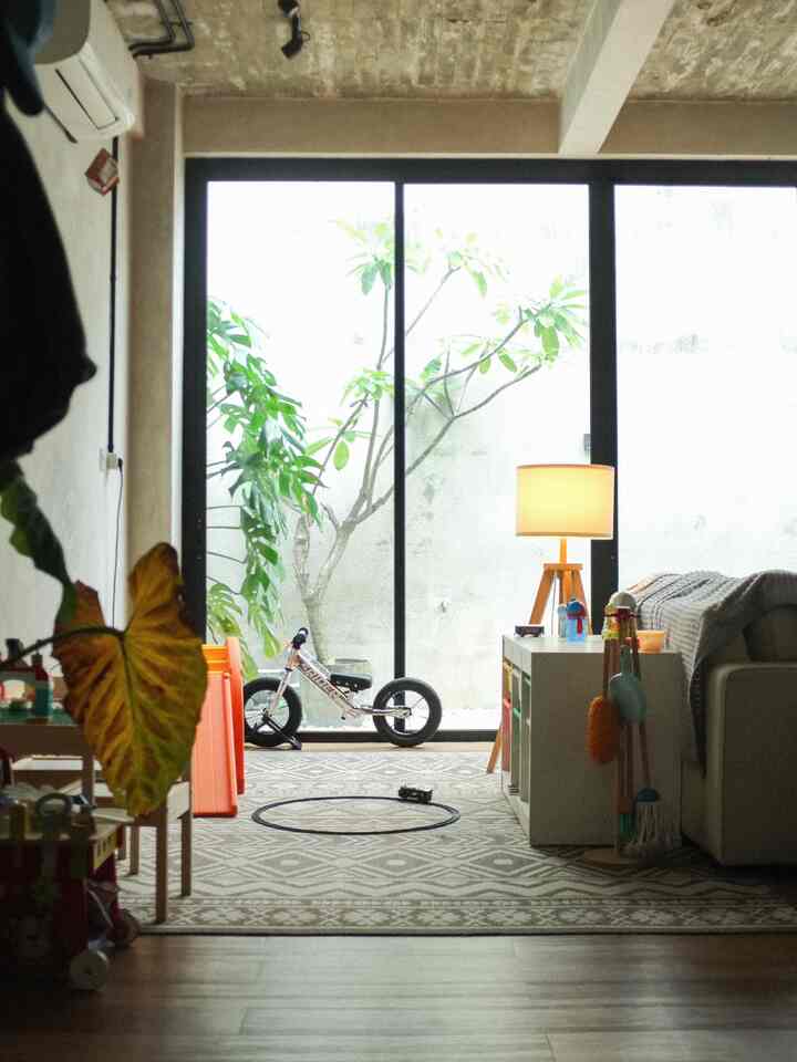 Natural tone living room featuring kids' toy storage and a floor lamp with a cozy atmosphere