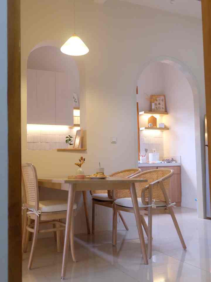 Bright natural-toned dining room featuring rattan dining chairs and wooden table in a cozy cafe style setting