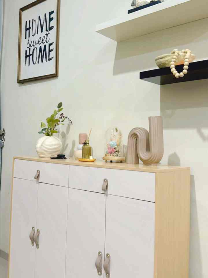 Natural and white tone entrance featuring a storage cabinet and decorative objets, creating a cozy atmosphere