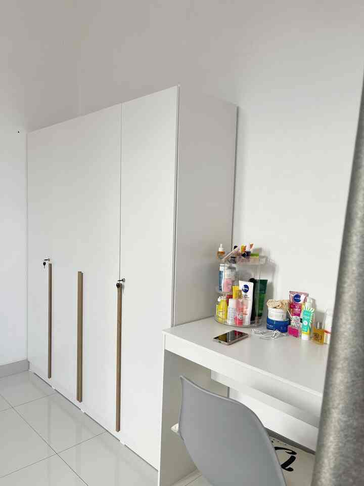 White and gray toned room featuring a large closet and a minimalist desk with neatly organized cosmetics, creating a clean space