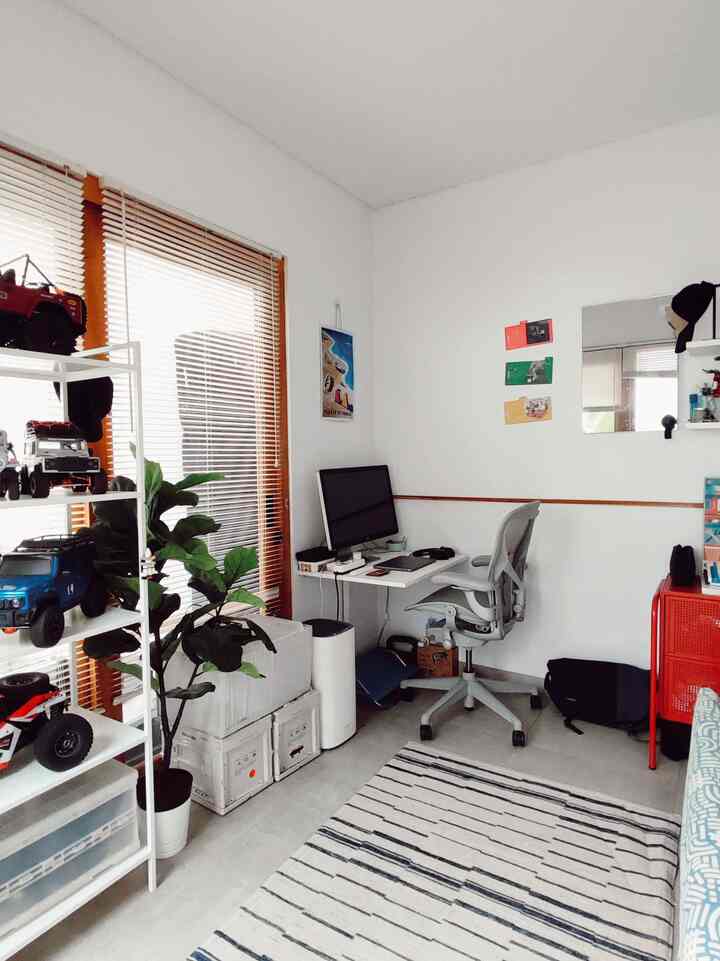 Bright white and orange tone home office featuring a desk and office chair with clean, organized workspace