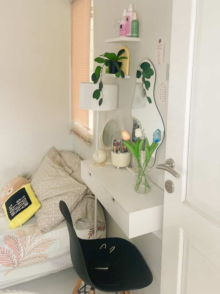 White and black toned small bedroom featuring a vanity desk and chair with a modern atmosphere