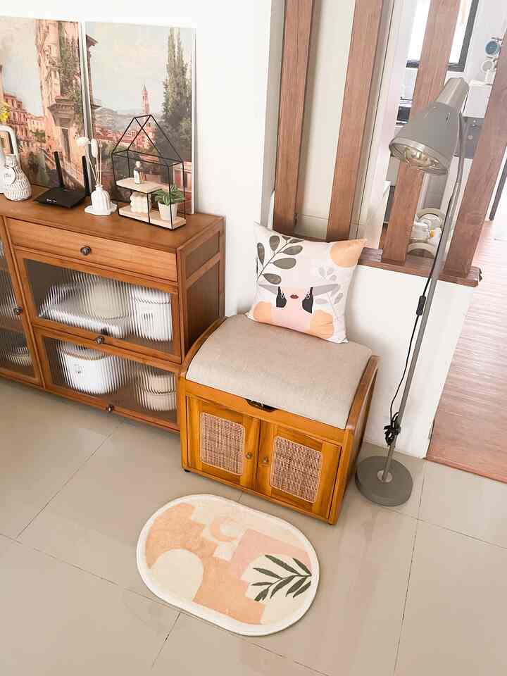 Entrance area in natural wood tones and beige colors, featuring storage cabinet, cushioned seat, and a decorative rug creating a cozy atmosphere