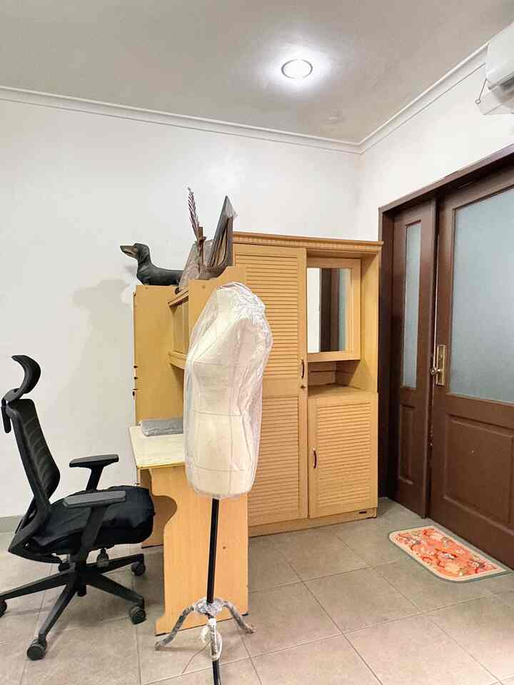 Small home office space with white walls and beige closet, featuring a black office chair
